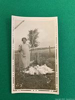 Front view of vintage photograph showing woman, geese, rural backdrop