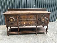 Full front view of sideboard showing drawers, cabinet doors, carving, lower shelf
