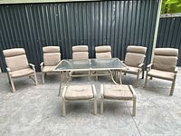 Full patio set showing table, six chairs and two ottomans
