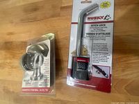 Both packaged items—Husky hitch lock and Weigh Safe adapter—on table