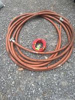 Coiled orange rubber hose with red hybrid hose inside