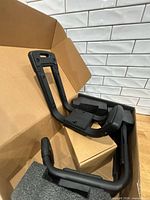 Box opened showing J-style carrier arms in foam