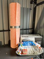 Underlayment roll, MAPEI mortar bag and Fusion Stone box on shelf