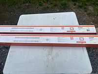 Two long Sylvania Vapor Tight fixture boxes on table