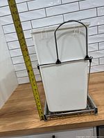 Bin in frame beside tape showing ~17 in height