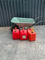 overall view of wheelbarrow and three gas cans