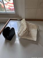 acrylic dispenser, ceramic holder, napkins on counter
