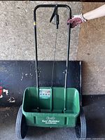 Front view of Scotts push broadcast spreader showing hopper, handle, wheels