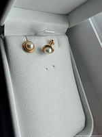 Earrings in box, frontal view showing pearls and gold bezels