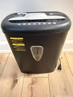 Front view of black Amazon Basics shredder showing bin and viewing window
