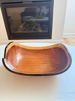 Top angled view of entire wooden bowl showing interior grain and black rim