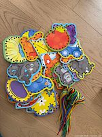Pile of colourful alphabet animal lacing cards with bundle of multicoloured laces