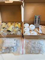 Overview of two boxes: gold candle shells, white tea lights, remote, instruction sheet, two bags of LED modules