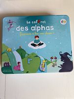 Front of blue metal tin showing Les Alphas branding