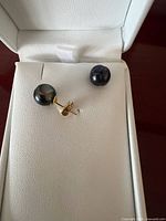 Earrings in box showing front view of pearls and gold posts