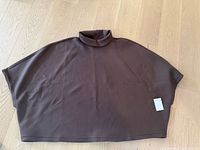 Full view of brown LEZÉ poncho laid flat