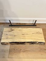 Wooden shelf plank front view with mounting bracket and pegs placed behind