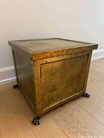 Front left view showing hammered brass panels, riveted edges, and claw feet
