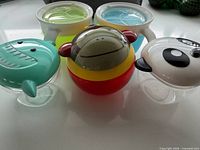 Front view of four animal motif snack cups and two handled cups