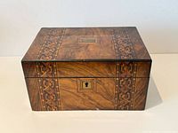 Front view of rosewood box showing marquetry inlay and keyhole