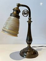 Full view of brass table lamp with iridescent shade standing upright