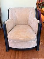 Front view of beige velvet tub chair with black lacquer frame
