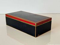 Closed box angled view showing enamel panels and brass trim