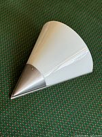 Wall sconce with white glass shade displayed on fabric background