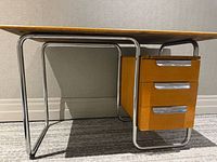 Full view showing desk front, chrome frame, wood pedestal drawers