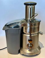 Complete juicer assembled showing motor base, pulp container, lid, feed chute and pusher