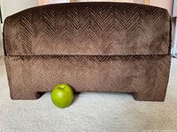 Front view of brown corduroy herringbone ottoman with apple for scale