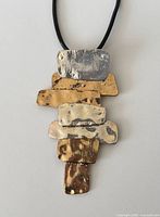 Close-up of pendant showing mixed metal rectangles