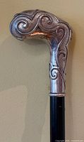 close-up of silver handle showing relief scrollwork