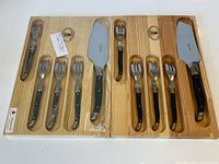 Two sealed wooden trays each with cake server and forks