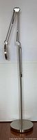 Full side view of brushed metal LED floor lamp with magnifier