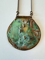 Front view of oxidized brass pendant on chain