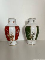 Front view of both Okura Toen vases showing red and green panel designs