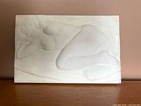Front view of plaster relief showing reclining nude figure