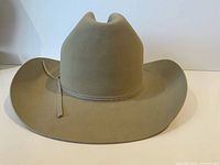 Side view of light tan felt cowboy hat showing crown shape and brim