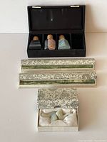 Overall lot showing stoppers in case, two brocade chopstick boxes and small brocade box with jade ducks