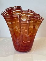 full front view of orange swirl ruffled glass vase