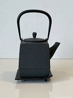 front view of cast iron teapot on trivet