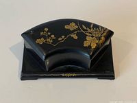 Top view showing fan-shaped lid with gold floral motif