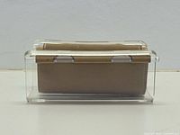 Front view of clear lucite eyeglass holder showing suede cradle