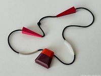 Full view of necklace showing pendant, cone beads, metal tubes and cord