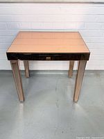 Front view of rose gold mirrored side table showing overall form and reflective surfaces