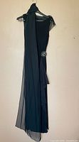 Front view of black ruched evening dress with attached scarf showing rhinestone hip detail