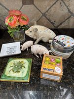 Overview of lot: pigs, vase with faux flowers, coasters, quote dish, tile coaster, chick magnets