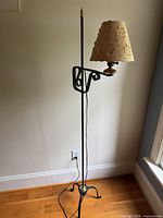 full view of black metal floor lamp showing shade, pole and base