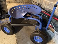 Overall view of blue rolling garden seat with tray, basket and tires